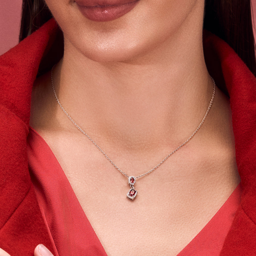 A woman wearing a Silver Pendant Adorned with Red Garnet and Cubic Zirconia.