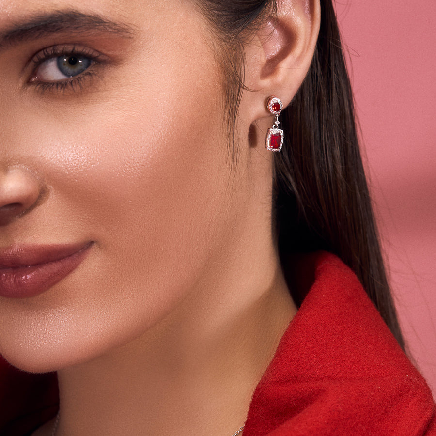 A woman wearing Silver Earrings Adorned with Red Garnet and Cubic Zirconia.