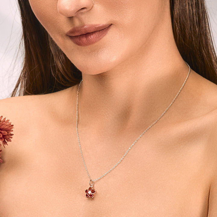 A woman wearing a Silver Pendant featured with Red Garnet and Cubic Zirconia.