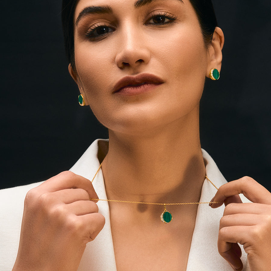 A woman wearing a Glamorous Green Malachite Pendant with Cubic Zirconia, Luxe Gold Finishing.