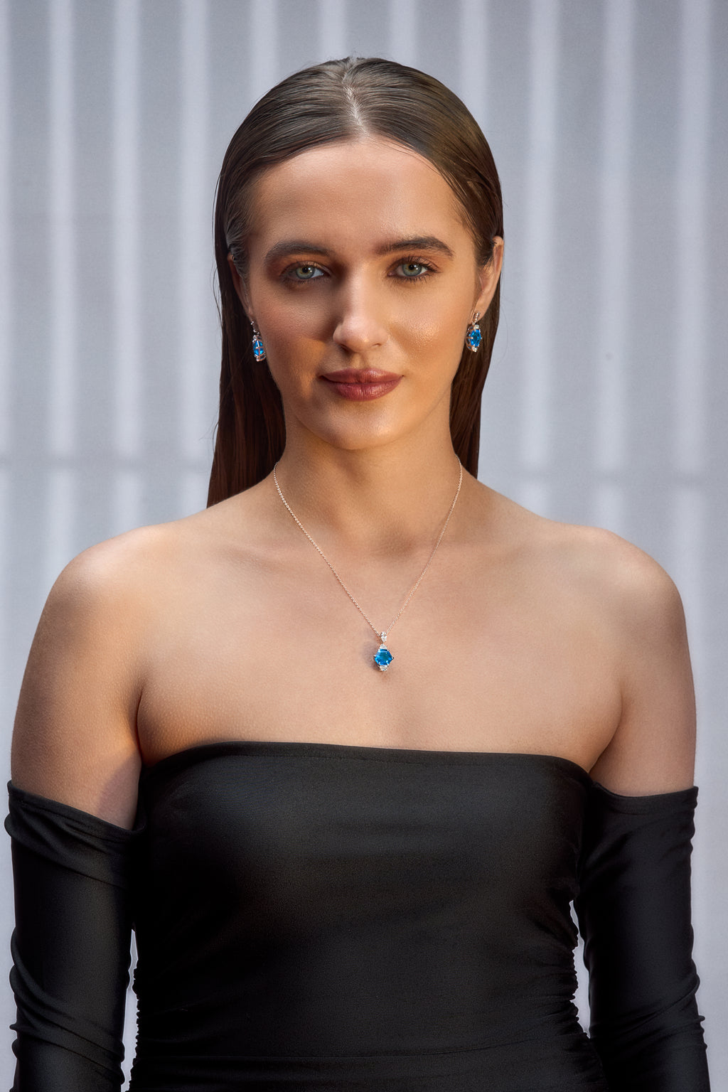 A woman wearing a combo of Blue Gem Earrings and Pendant Set with Silver Chain.