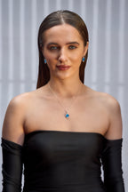 A woman wearing a combo of Blue Gem Earrings and Pendant Set with Silver Chain.