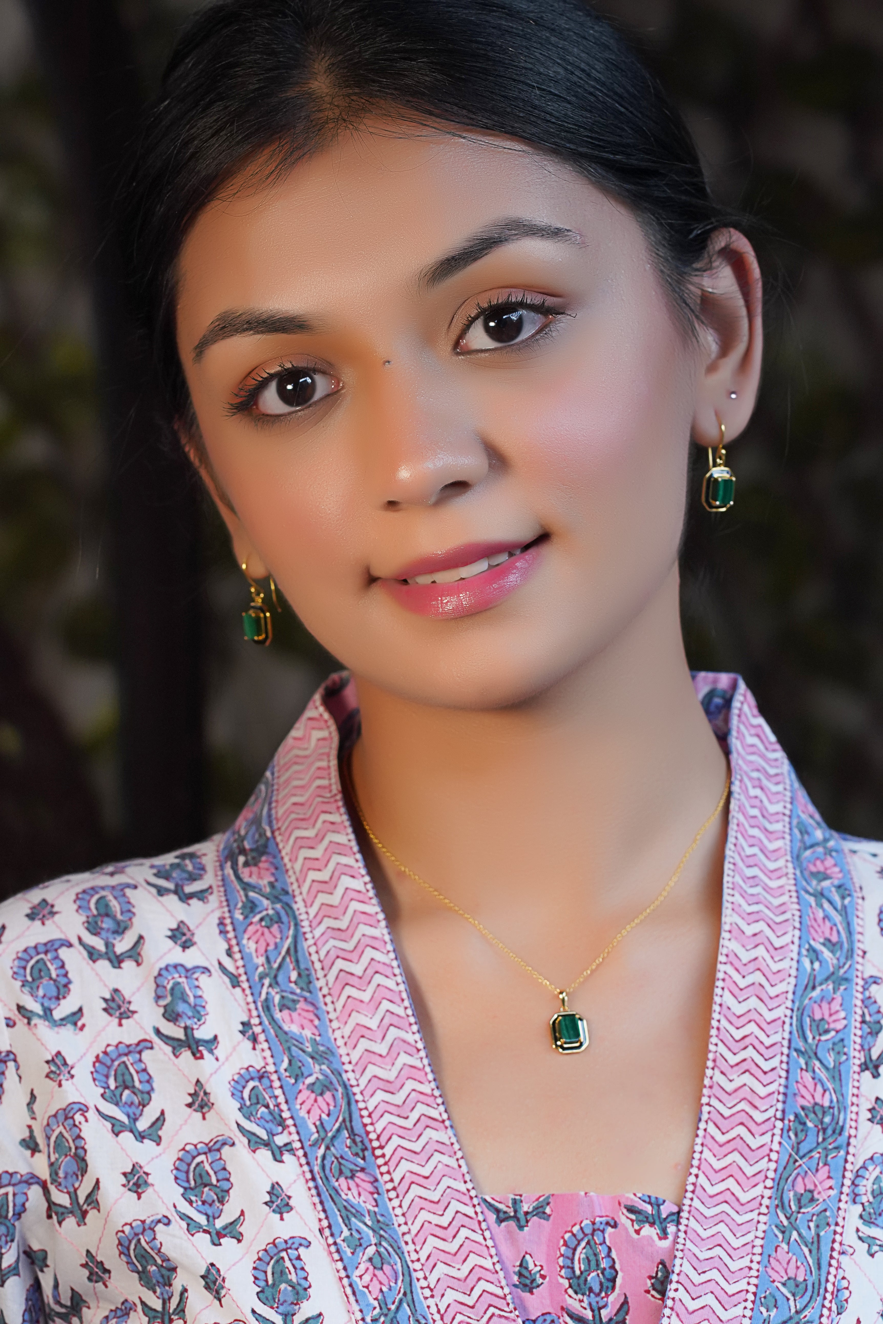 A woman wearing Mystic Malachite Green Earrings made with Sparkling Cubic Zirconia.