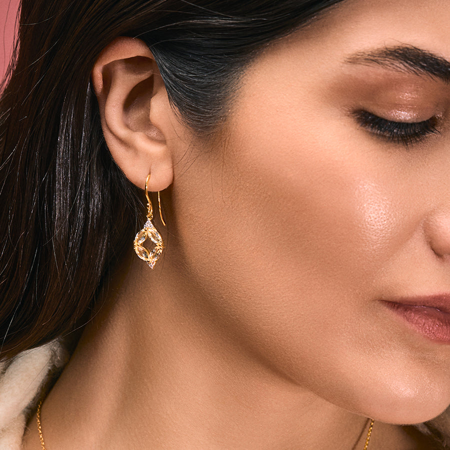 A woman wearing Dangle Earrings adorned with Cubic Zirconia and Light Green Amethyst.